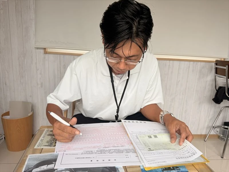 ハッピーカーズ福山店で買取車の名義変更手続きを行う様子