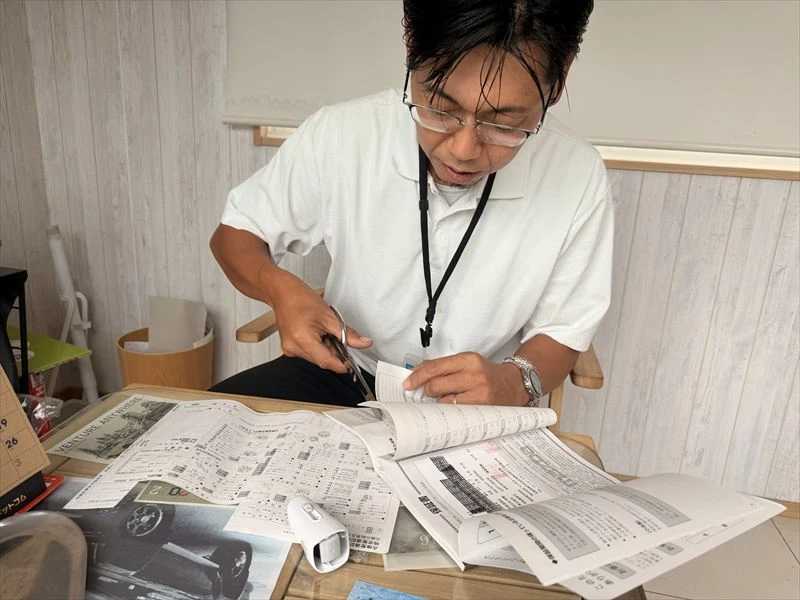 買取車の整備記録簿に残る個人情報を確認し処理する様子